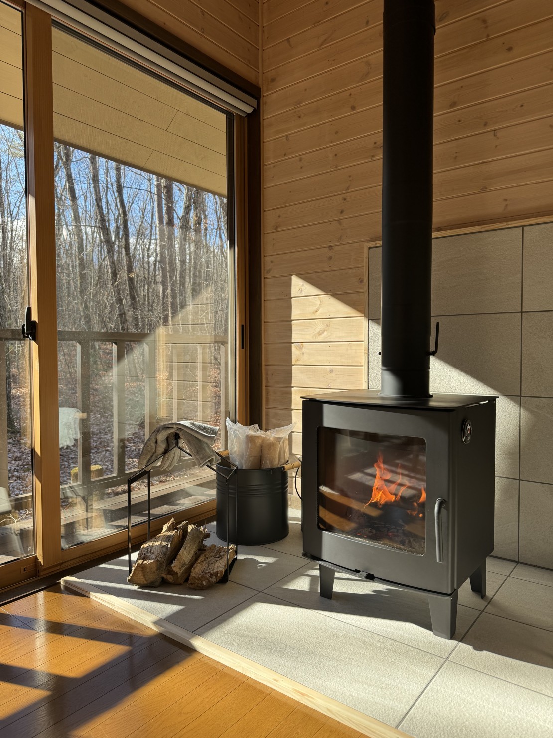 Second House ホッポッタ｜群馬県・北軽井沢・嬬恋・万座｜薪ストーブの炎を見ながら、ふと目を窓に向けると、木立の隙間から浅間山を見ることができます。（薪ストーブは冬季オプション）