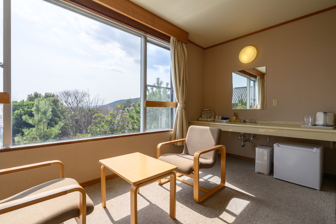 伊豆iroha｜静岡県・伊豆高原｜窓の向こうに広がるのは、木々の緑とやわらかな山の稜線。
何も足さず、何も引かず。
自然光がそっと包み込むこの眺めは、心の緊張をゆるめる静かな処方箋です。