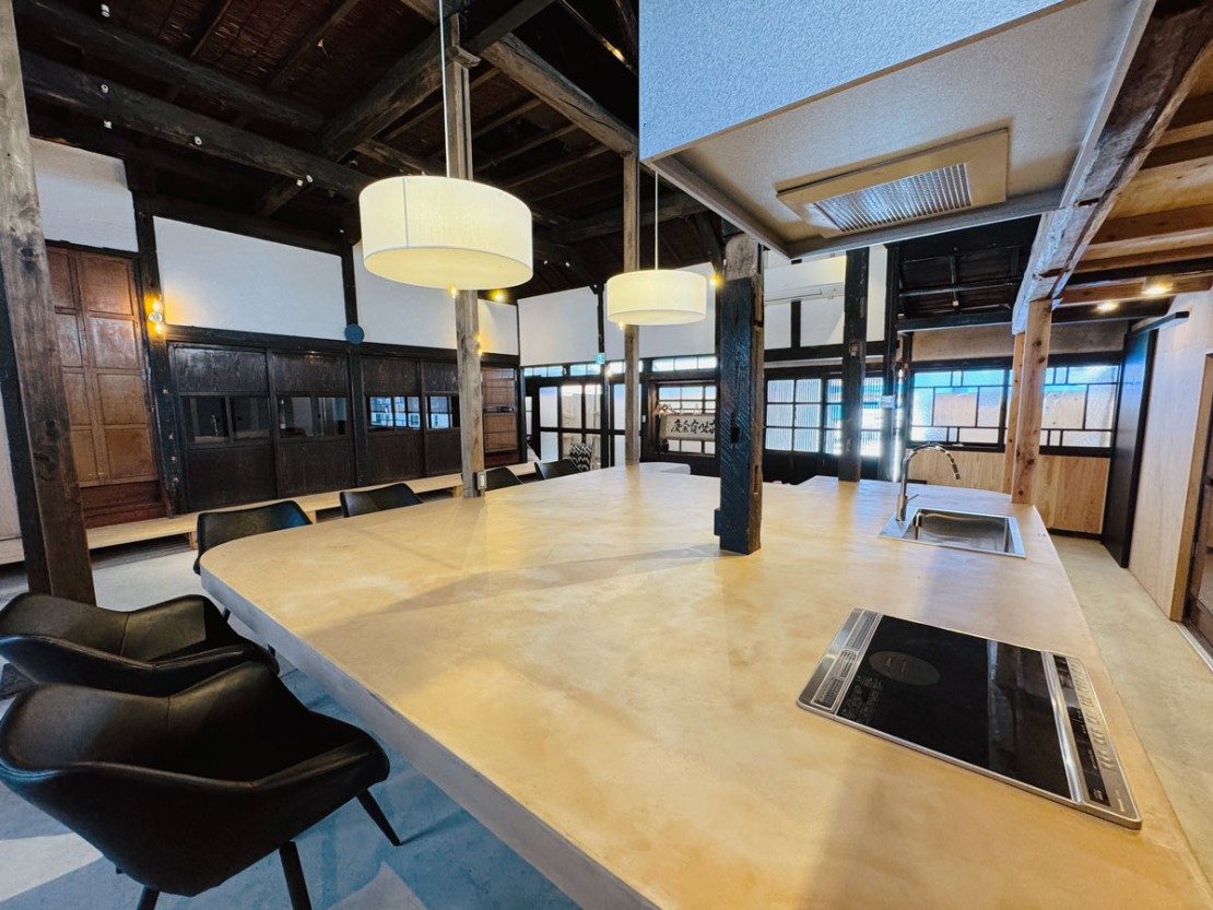 いにしえの宿おへそ｜山形県・米沢・置賜｜土間には、流し台とIH完備の広々ダイニングテーブルがございます。調理器具や食器類は一通りご用意しておりますので、自炊の際はご利用ください。